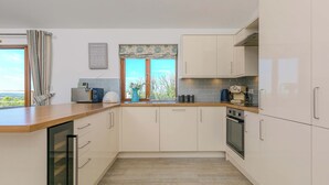 A modern kitchen with light-colored cabinets, a wooden countertop, and a view of the outdoors. - Mellydonen Beder Del , Tor Down Quarry (Bodmin)