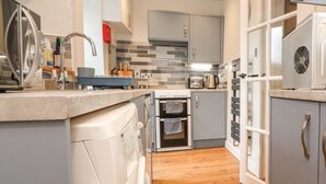 A modern kitchen with a dishwasher, oven, and a built-in microwave.