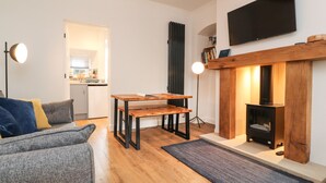 A modern living room with a fireplace, a dining table, and a sofa.