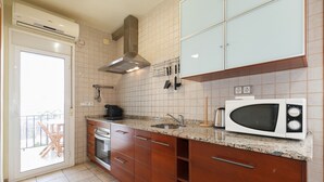Una cocina equipada con microondas, estufa, lavaplatos y armarios.