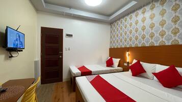Une chambre d’hôtel avec deux lits, une télévision, un bureau et une chaise.