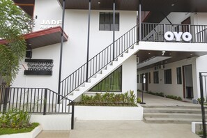A modern building with a staircase leading to a balcony, labeled "JADE" and "OYO". - OYO 736 Jade Apartelle (Cabuyao)