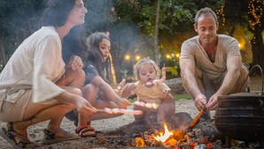A family gathered around a campfire with a pot on a portable stove. - Camping Dafna - By Travel Hotel Chain (HaGalil HaElyon)