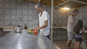 A kitchen with a long countertop, patterned wallpaper, and a hanging light fixture. - Camping Dafna - By Travel Hotel Chain (HaGalil HaElyon)