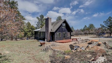 Escape to a serene cabin surrounded by nature, with a spacious deck perfect for relaxation and socializing.