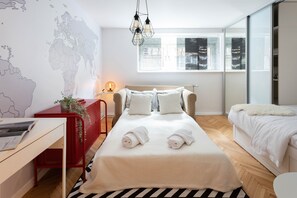 Laptop workspace, iron/ironing board, bed sheets