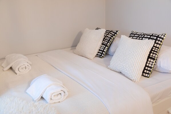 Laptop workspace, iron/ironing board, bed sheets