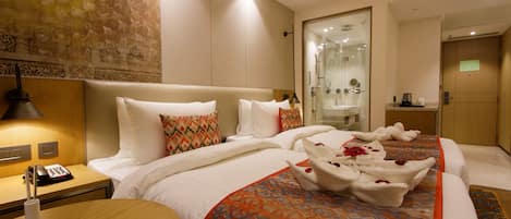A hotel room with a bed, bedside table, and a mirror.
