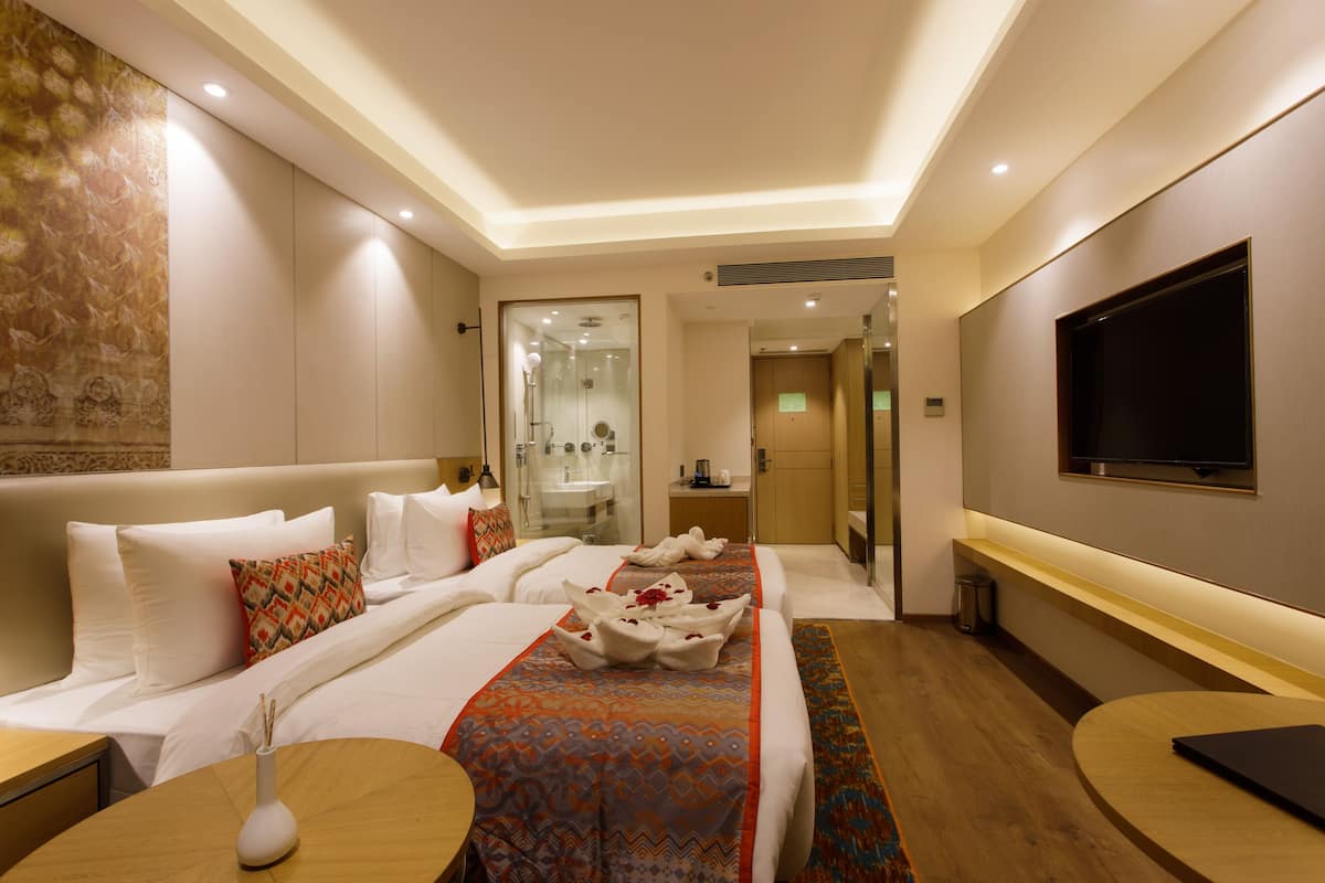 Une chambre d’hôtel avec un lit, une télévision, une salle de bain et un bureau.