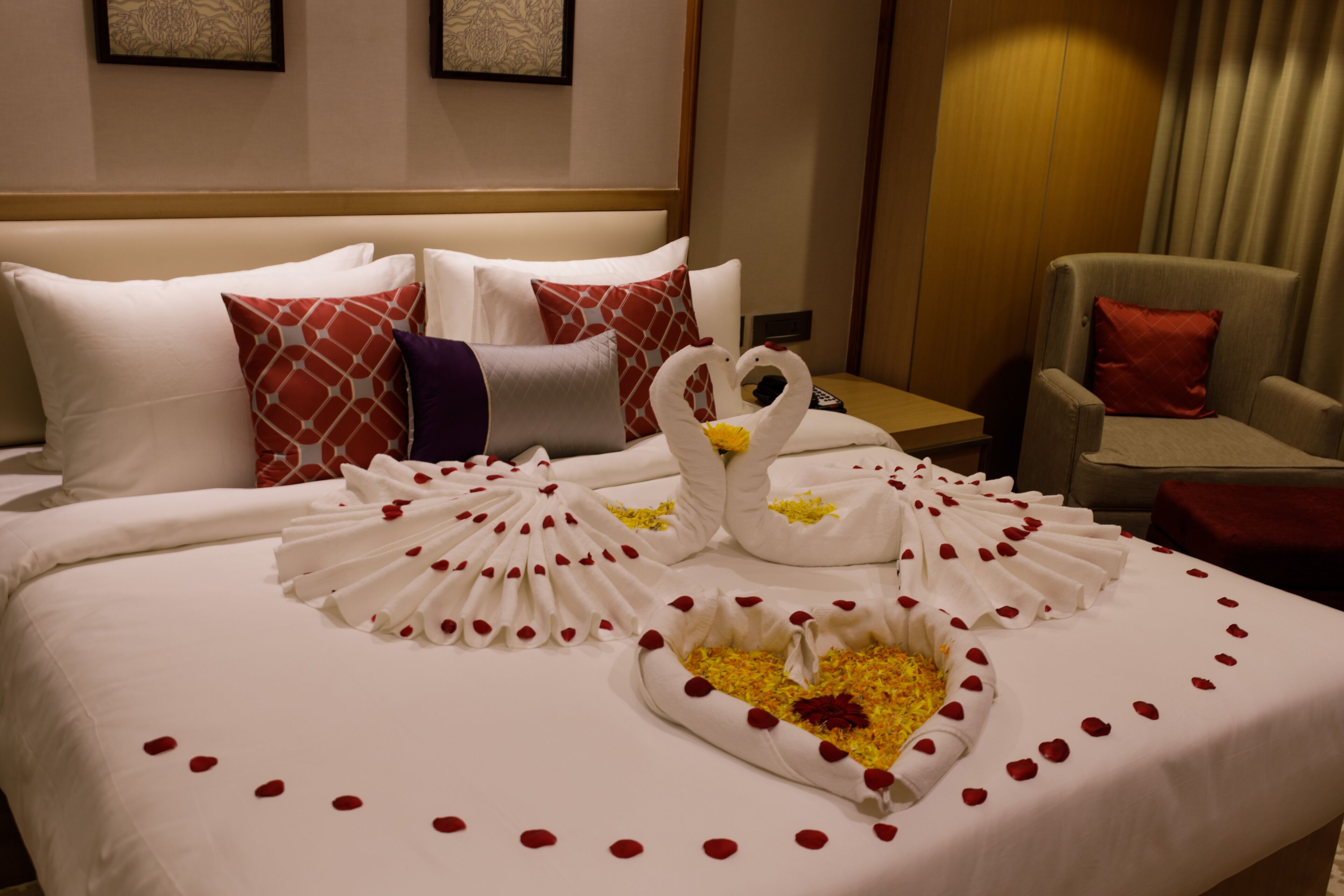 Ein Hotelzimmer mit einem ordentlich bezogenen Bett, einem Sessel und einem kleinen Tisch.