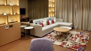 Una sala moderna con un sofá modular, una mesa de centro y una alfombra estampada.