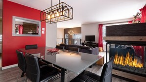Ein modernes Wohnzimmer mit Essbereich, Kamin und einem großen Spiegel an der Wand.