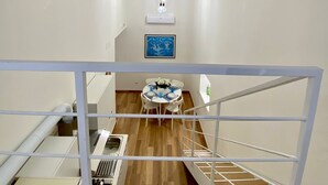 Eine moderne Küche mit Holzboden, weißen Schränken und einer weißen Geländer.