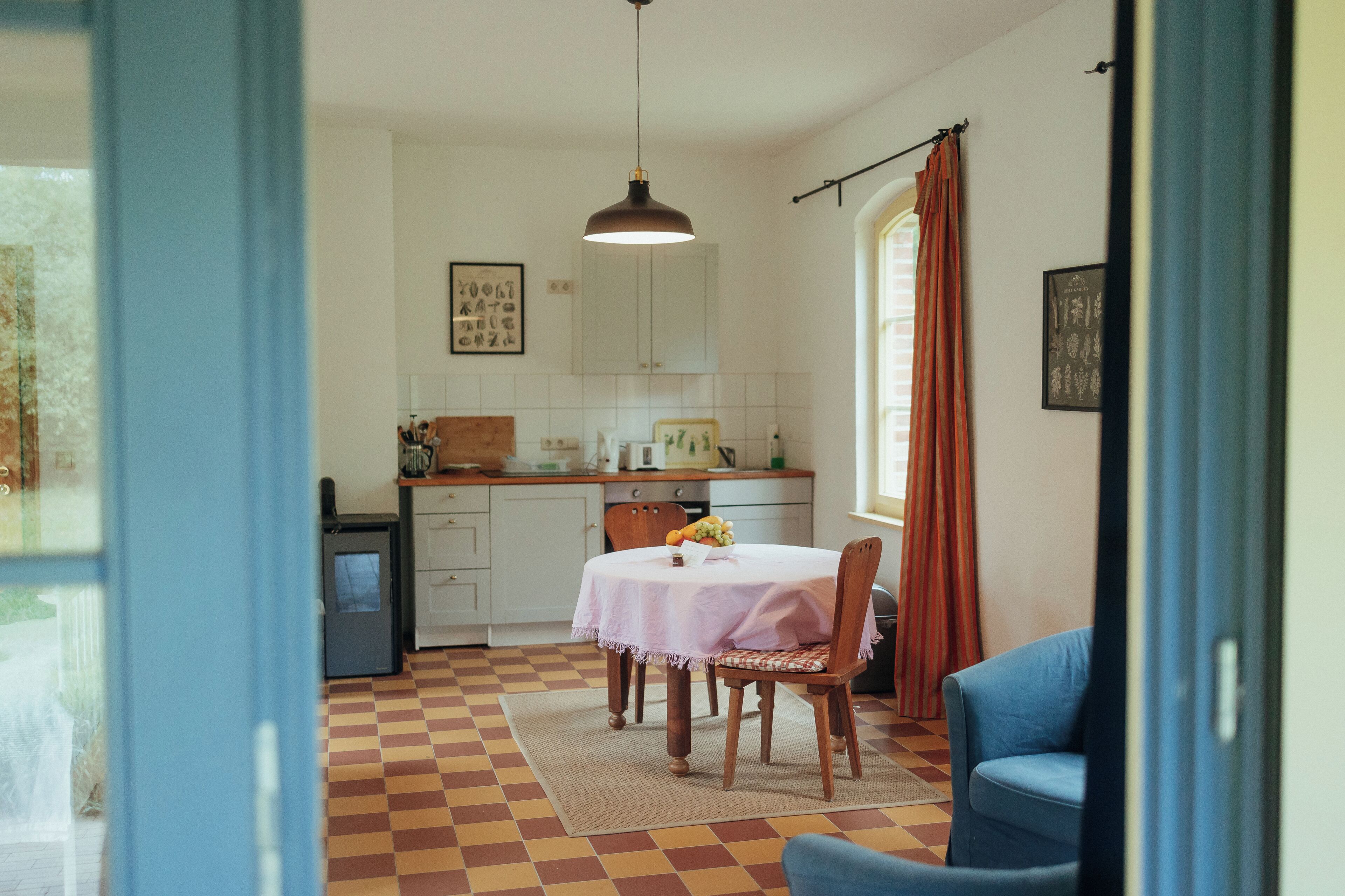A kitchen with a dining table, chairs, and a blue chair in the foreground.