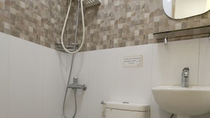 A bathroom with a toilet, shower, and sink. - Freemont Place (Parañaque)