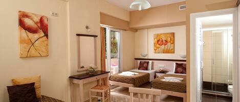 A compact hotel room with a kitchenette, a dining area, and a bed.