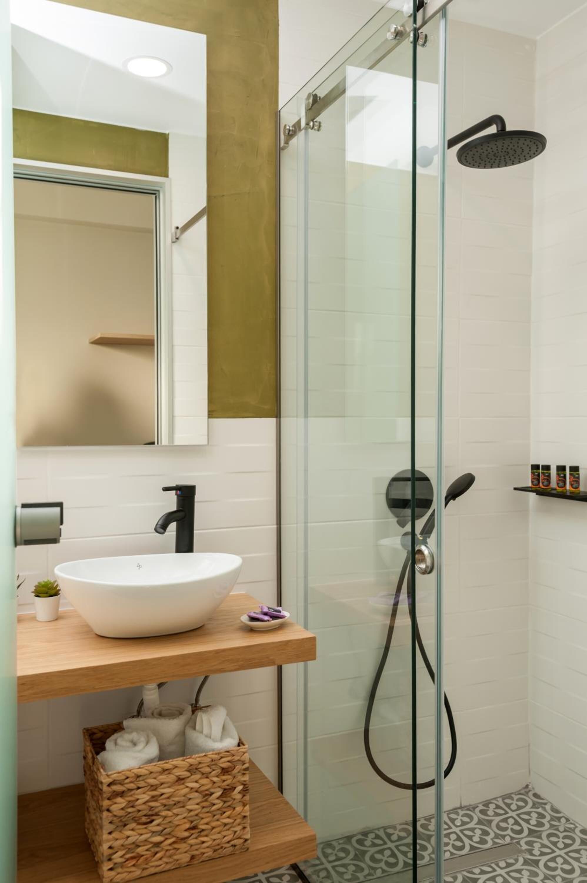 Ein modernes Badezimmer mit einer Duschkabine aus Glas, einem weißen Waschbecken und einem Holzbadezimmermöbel.