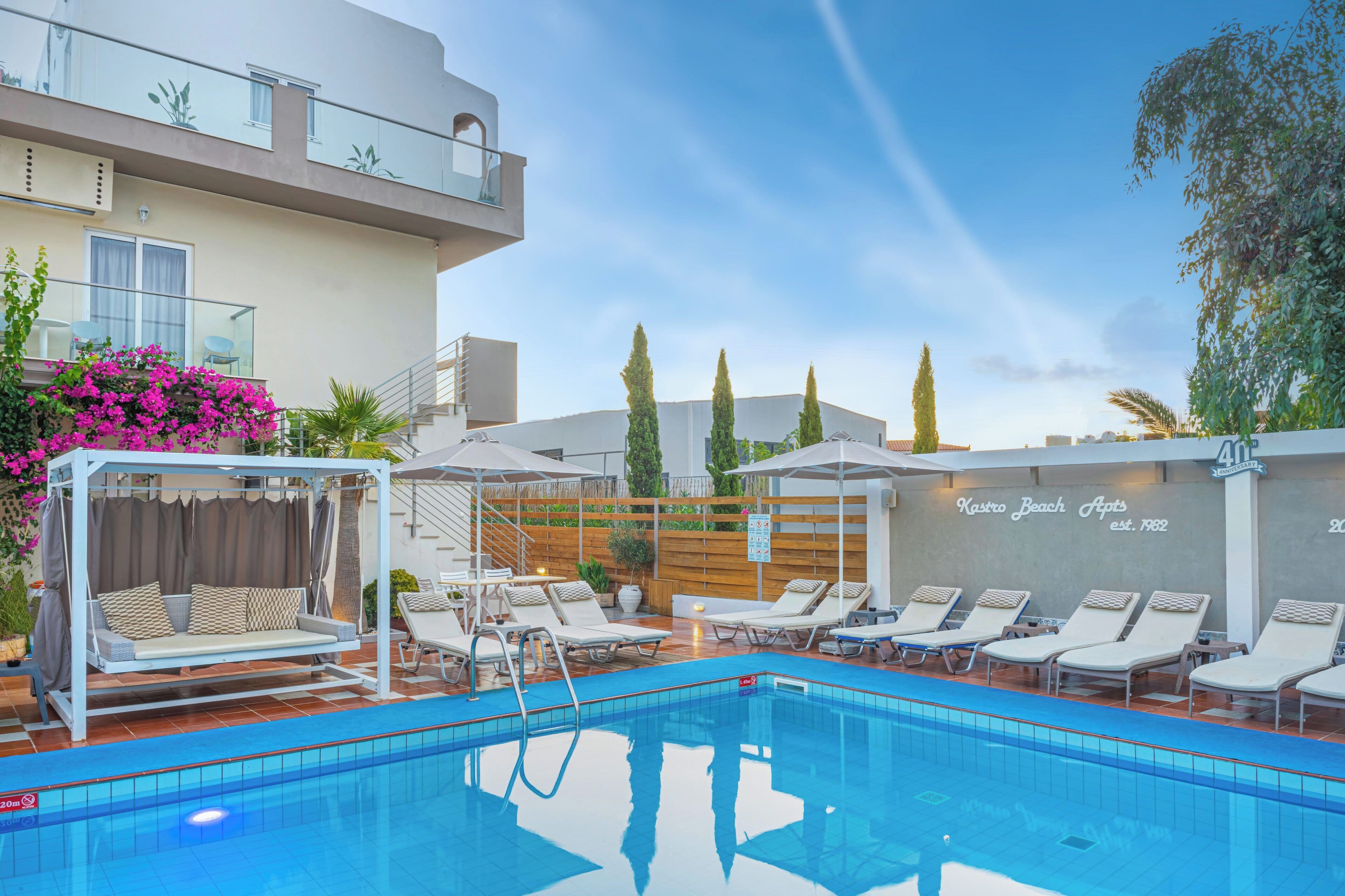 Ein Pool mit Liegestühlen und einer überdachten Sitzgruppe.