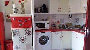 A compact kitchen with a washing machine, a microwave, and a coffee maker. - Résidence la Goyave (Biscarrosse de la plage)