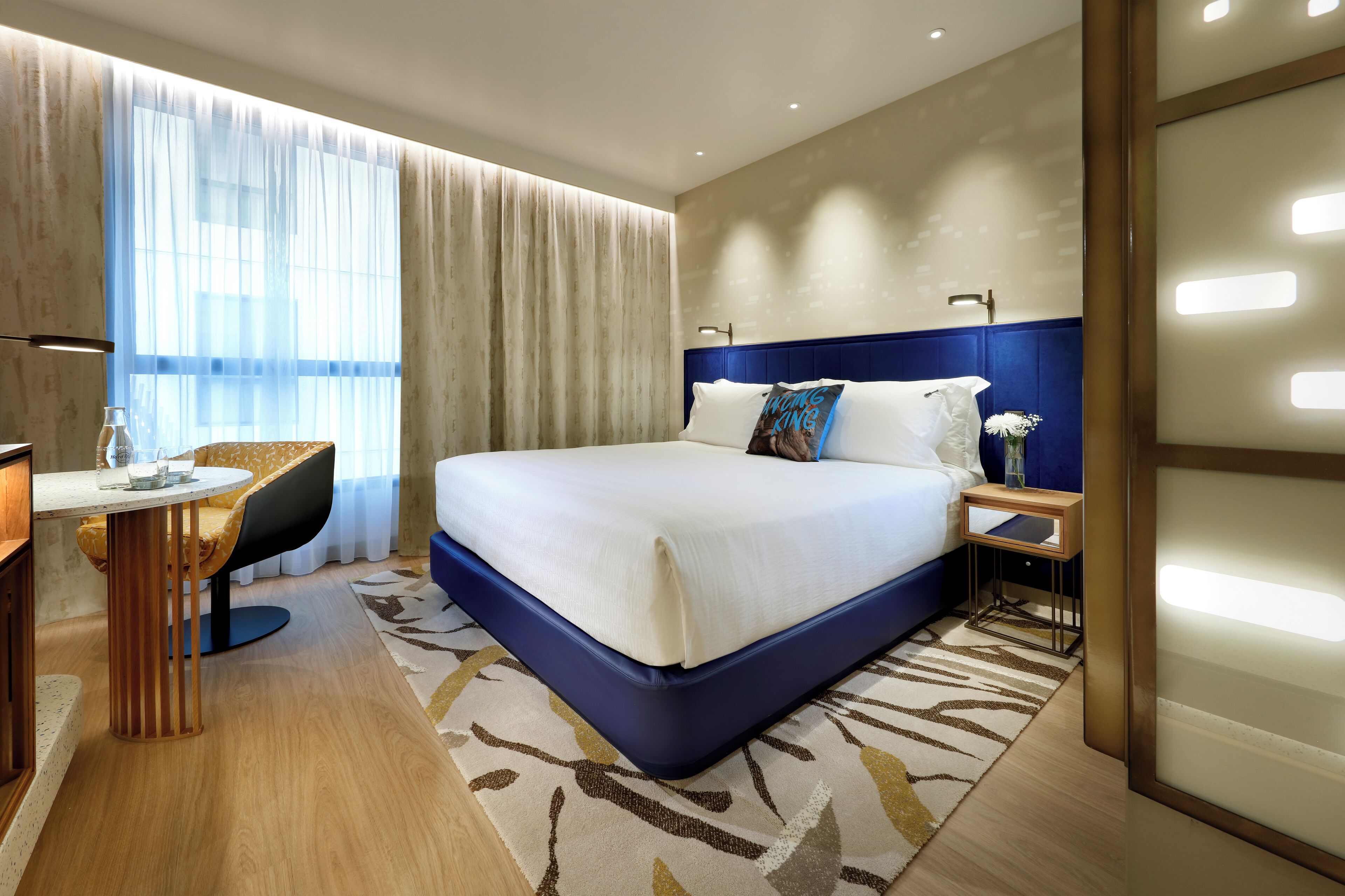 Ein modernes Hotelzimmer mit einem großen Bett, einem Schreibtisch und einem Sessel.