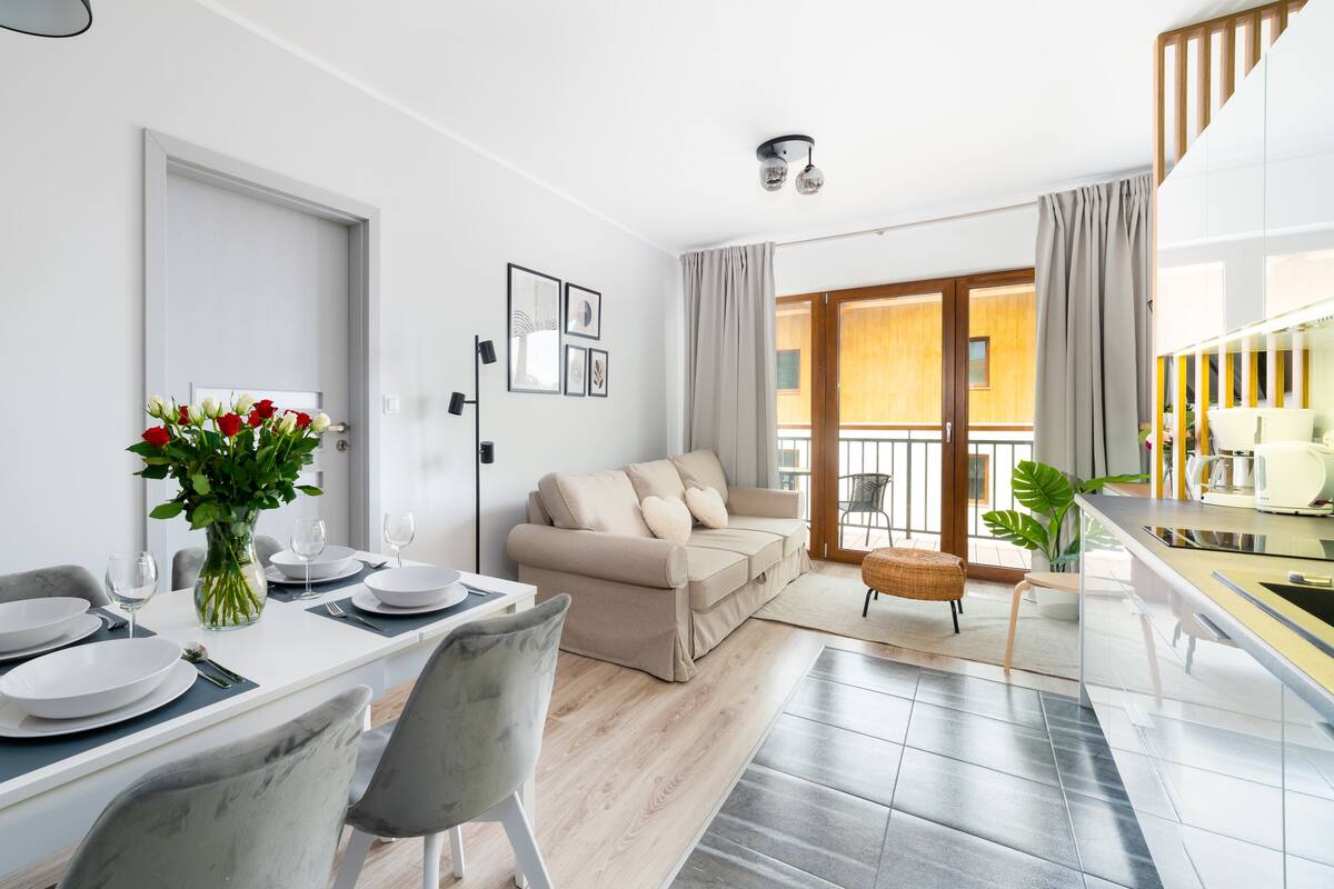 Un appartement moderne comprenant un coin repas, un canapé et un balcon.
