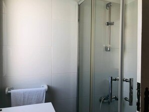 A modern bathroom with a glass shower enclosure, a white sink, and a towel rack. - Remarkable 3-bed House in Albufeira (Albufeira)
