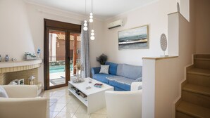 A modern living room with a sofa, coffee table, and a staircase. - Anastasia Villa, Libyan SeaViews with Heated Pool (Sellia, Rethymno)