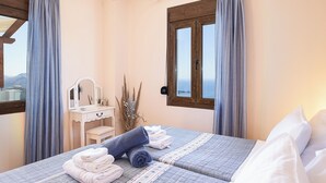 A bedroom with a bed, a vanity with a mirror, and a window with curtains. - Anastasia Villa, Libyan SeaViews with Heated Pool (Sellia, Rethymno)