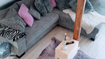Una sala de estar acogedora con un sofá seccional gris, una mesa de centro de madera y una alfombra de piel única.
