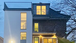 Ein modernes, zweistöckiges Gebäude mit großen Fenstern und einem Balkon.