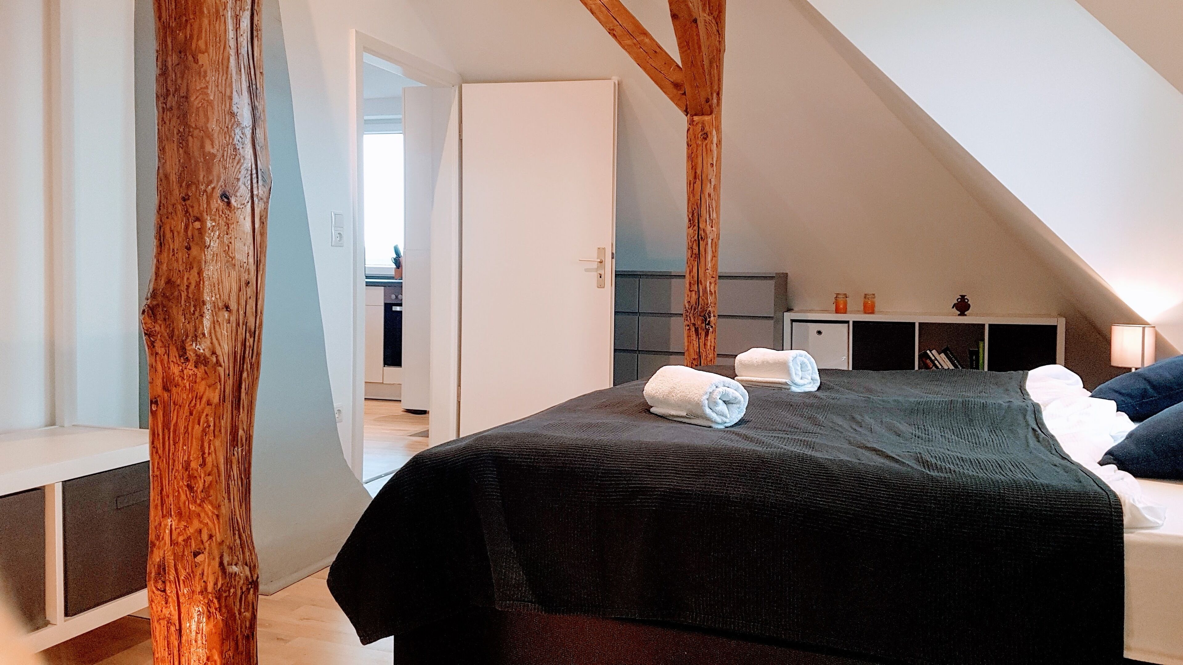 Een slaapkamer met een groot bed, een bureau en een kledingkast.