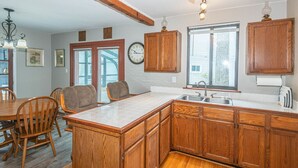 A kitchen with wooden cabinets, a large island, and a dining area with chairs. - Lakeside Fee-lings on Strawberry Lake kayaks Included or bring boat with you. (Lakeland)