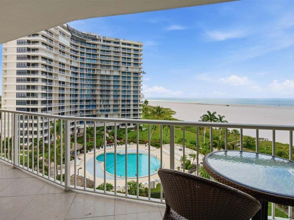 Een hoog hotel met zwembad en uitzicht op het strand.