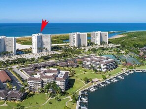 An aerial view of a coastal hotel complex with multiple buildings, a marina, and a beach. - Beachfront 2BR/2BA condo on Marco Island with pool and WiFi. (Marco Island)