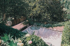 A garden with a paved area, metal chairs, and a variety of plants. - Casa Didi - 3km do centro -  by Trip2Portugal (Sintra)