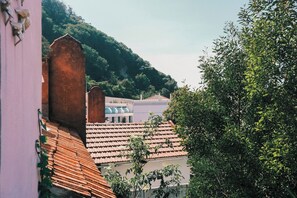 A residential area with terracotta-tiled roofs, a hillside in the background, and lush greenery. - Casa Didi - 3km do centro -  by Trip2Portugal (Sintra)