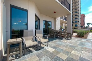 Relax on the patio with a seating area featuring two chairs and a table, adjacent to a garden with a winding pathway.