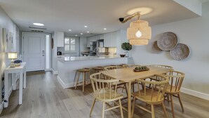 Eine moderne Küche mit einer zentralen Kochinsel, einem Holzespeisetisch und Stühlen.