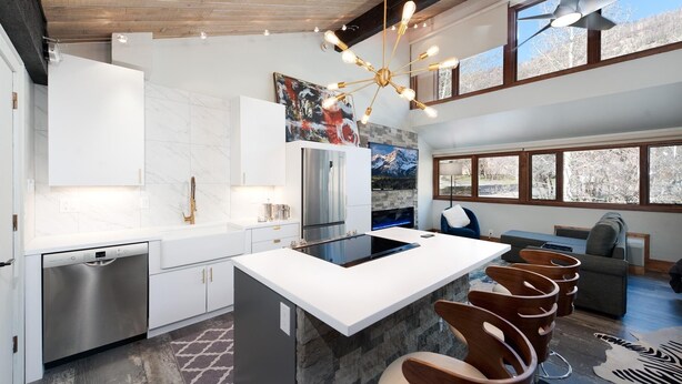 A modern kitchen with a central island, stainless steel appliances, and a unique chandelier. - Sunshine Suite | AC, Pool, Hot Tub, Golf & Ski (Durango)