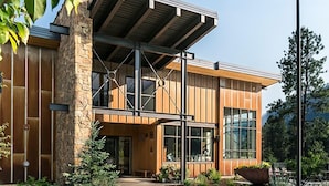 A modern building with a stone facade, large windows, and a covered entrance area. - Sunshine Suite | AC, Pool, Hot Tub, Golf & Ski (Durango)