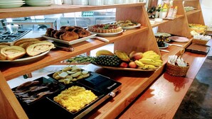 Ein reichhaltiges Buffet mit verschiedenen Speisen, darunter Brot, Fr üchte und Rührei.
