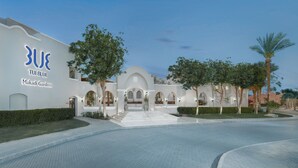 A modern building with a white facade, arched walkways, and Makadi Gardens signage. - Jaz Makadi Gardens - TUI BLUE Makadi Gardens - Adults Friendly 16 Years Plus (Makadi Bay)