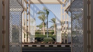 An arched structure with intricate lattice work, leading to a view of palm trees and a building in the background. - TUI MAGIC LIFE Redsina Sharm El Sheikh (Sharm El Sheikh)