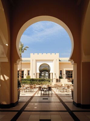 Relax in a serene outdoor space with a central seating area and views of the building's entrance.