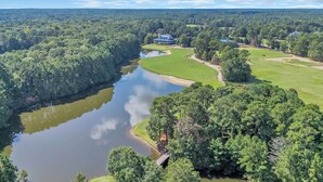 A large estate with a lake, golf course, and a prominent house with a blue roof. - TB 9G Great dog friendly 2 bedroom condo on the golf course at True Blue 9G (Pawleys Island)