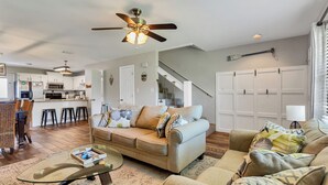 A modern living room with a sofa, coffee table, and a ceiling fan. - Emerald Escapes unit 41 (Miramar Beach)