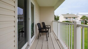 A wooden porch with two chairs and a glass door. - Emerald Escapes unit 41 (Miramar Beach)