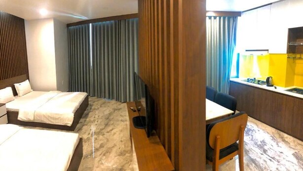 A hotel room with two beds, a desk, a chair, a TV, and a window with curtains. - HANZ Happy Hotel 7 Ly Thai To (Ho Chi Minh City)