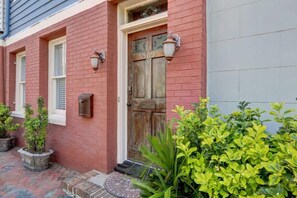 A red brick house with a wooden front door, numbered 509, and two wall-mounted light fixtures. - York Street Gem - A Taste of 1800s Savannah (Savannah)