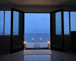 An open doorway leading to a beach with a view of the sea and a clear sky. - PRIVATE BEACH: A SLICE OF HEAVEN @ NIANTIC W/ 6 QUEENS 1 FULL BED (East Lyme)